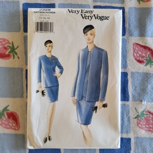 Puede incluir: Un patrón de costura para un traje de falda azul con chaqueta y falda. El patrón es para las tallas 14-16-18. El patrón se llama "Very Easy Very Vogue" y el número de patrón es 9328.