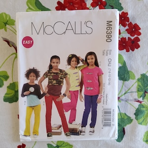 May include: A sewing pattern for making children's clothing. The pattern is for sizes 7-8, 10-12, and 14. The pattern is called McCall's M6390 CHJ. The pattern includes instructions for making a variety of tops and pants.