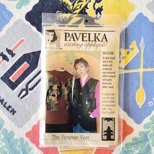 May include: A package for "The Venetian Vest" by Pavelka, featuring a woman and a vest. The package includes a photo of the vest and a woman wearing a similar vest. Text on the package reads "exciting appliqué!" and describes the vest.