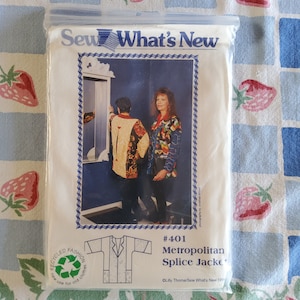 Puede incluir: Patrón de costura Sew What's New #401 para una chaqueta Metropolitan Splice. El patrón muestra a una mujer usando una chaqueta colorida con un diseño geométrico. El patrón está sobre un fondo blanco con un borde azul.