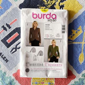 Könnte beinhalten: Ein Burda Style Schnittmusterpaket mit Abbildungen von Jacken. Das Paket enthält den Text "JACKE, VESTE, JACKET, CHAQUETA" und Größenangaben. Das Hauptbild zeigt eine Frau in einer braunen Jacke mit Knöpfen.