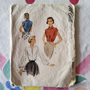 May include: A vintage McCall's sewing pattern for a women's blouse. The pattern is for sizes 12, 30, 36, and 45 bust. The pattern shows three different styles of blouses, all with long sleeves. The pattern is printed on a white background with black text. The pattern is titled "Misses' Blouse" and the number "8062" is printed in the corner.