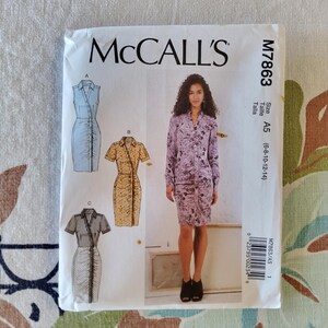 May include: A McCall's sewing pattern envelope, M7863, featuring illustrations of three dress designs. The envelope is white with the McCall's logo and size information. The dress designs include a light blue, a tan, and a striped dress.