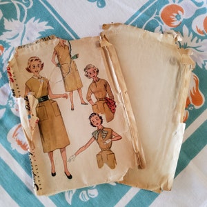 Puede incluir: Patrón de costura vintage con instrucciones para hacer un vestido. El patrón presenta a tres mujeres con diferentes estilos de vestidos. El patrón está impreso en papel amarillento con el título 'Simple de hacer'.
