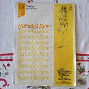 May include: A yellow sewing pattern for a tank suit. The pattern is designed exclusively for knit fabrics by Ann Person. The pattern number is 1320.