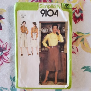 May include: Simplicity sewing pattern number 9104 for a skirt. The pattern shows a woman wearing a brown skirt with a yellow blouse and a white blouse with a brown skirt. The pattern is for size 10 miss.
