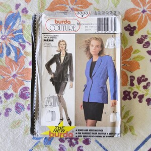 Puede incluir: Un paquete de patrones de costura Burda Couture con un diseño de traje. El paquete muestra ilustraciones de un traje negro y una blazer azul con una falda negra. El texto incluye "SUIT/TAILLEUR/TRAJE SASTRE" y "SEAMS AND HEMS INCLUDED".