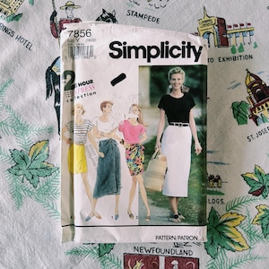 May include: A Simplicity sewing pattern envelope, number 7856, size Y (18-22), from the 2 Hour Express collection. The front features illustrations of four different skirt styles, including a yellow skirt, a blue wrap skirt, a floral skirt, and a white skirt.