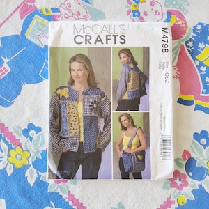 May include: McCall's Crafts M4798 sewing pattern envelope featuring a patchwork jacket and shoulder bag. The jacket displays blue and yellow fabric squares with butterfly and flower appliqués. The bag matches the jacket's patchwork design.