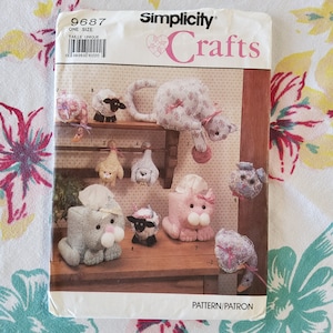 May include: A Simplicity Crafts sewing pattern for making tissue box covers. The pattern includes instructions for making a cat, a lamb, a duck, and a dog. The pattern number is 9687.