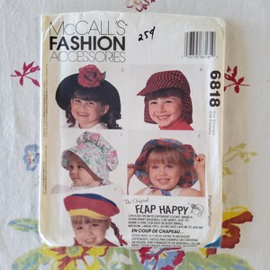 May include: McCall's Fashion Accessories pattern for children's hats. The pattern features images of children wearing different hat styles, including sunbonnets and baseball caps. The text on the pattern reads "FLAP HAPPY" and includes size information, from 19 to 22 inches.
