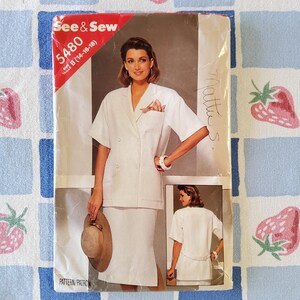 Peut inclure: Un patron de couture See & Sew vintage, représentant une femme en tailleur jupe blanc avec une veste croisée et une jupe assortie. Le paquet porte le numéro 5480 et la taille B (14-16-18). Le paquet est sur un fond à carreaux bleu et blanc.