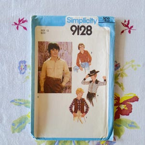 Può includere: Una busta per cartamodello Simplicity 9128 per ragazzo, taglia 12. Il fronte presenta illustrazioni e una fotografia di vari stili di camicie e gilet, tra cui una camicia a maniche lunghe, una camicia a fantasia e un gilet a quadri.
