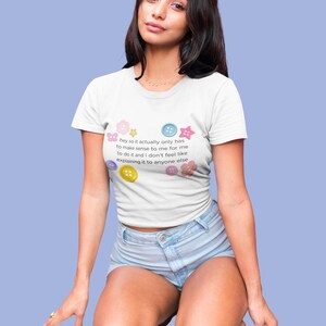 May include: White t-shirt with the text "hey so it actually only has to make sense to me for me to do it and I don't feel like explaining it to anyone else." The shirt has colourful button graphics.