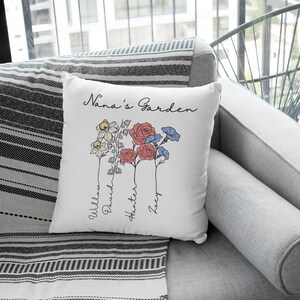 May include: White cushion with the text "Nana's Garden" and a floral design with four flowers. The names Willow, David, Hunter, and Zoey are written below the flowers.