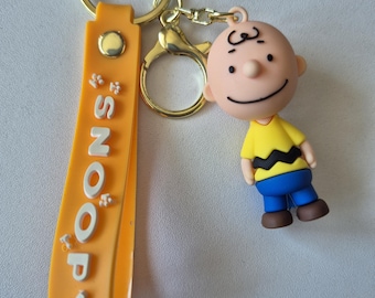 Charming Snoopy Keychain – Charlie Brown Figure with ornage Hand Strap and Snoopy logo