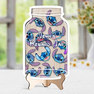 Pode incluir: Um quadro de recompensas de madeira em forma de frasco, com um fundo de grão de madeira clara e várias ilustrações da personagem azul Stitch. O texto "John's Reward Jar" está impresso no centro. O quadro repousa sobre um pequeno suporte de madeira.