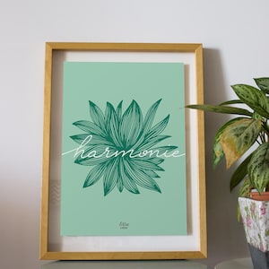 Peut inclure: Impression d'art encadrée avec un fond vert d'eau, un motif floral vert et le mot "harmonie" en cursive. L'impression est dans un cadre doré, exposée sur une table bleu clair. Une plante en pot est visible à droite.