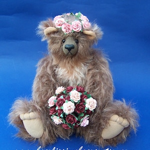 May include: A brown teddy bear wearing a pink flower crown and holding a bouquet of pink and burgundy roses. The bear is sitting on a blue background. www.bearlisssimobears.etsy.com