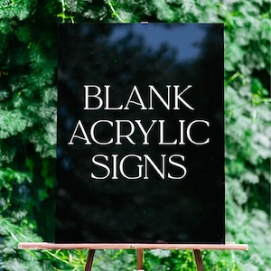 Peut inclure: Un panneau rectangulaire en acrylique noir portant le texte blanc BLANK ACRYLIC SIGNS dans une police serif. Le panneau est monté sur un chevalet tripode en bois brun. La surface de l'acrylique est lisse et réfléchissante, avec une finition brillante.