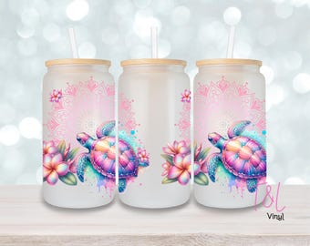 May include: Three frosted glass tumblers with lids and straws. Each tumbler features a pink mandala design with a colorful sea turtle swimming in front of it. The tumblers are perfect for enjoying your favorite beverages.