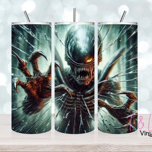 May include: Three stainless steel tumblers with a sci-fi horror design. The design features a menacing alien creature breaking through shattered glass. The alien has sharp claws and teeth, with a dark colour palette. Each tumbler has a silver straw.