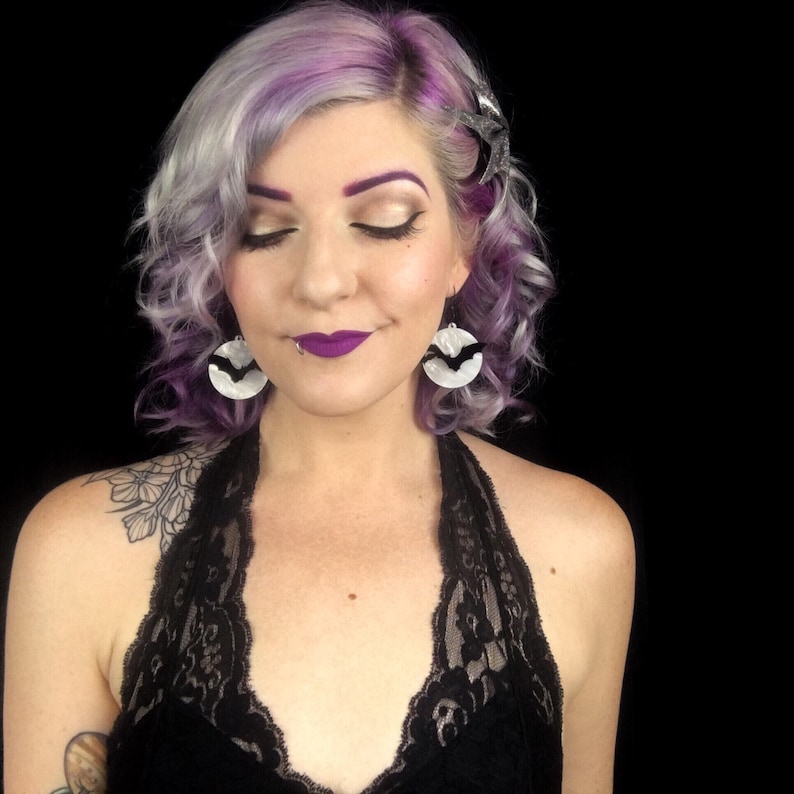 Woman wearing white pearl moon Halloween bat earrings with black bats, gothic witchcore costume jewelry for October style.