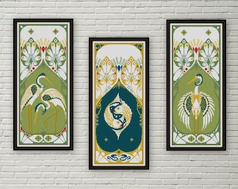 May include: Three framed art prints with a green background and white and yellow geometric designs. The center print features two stylized fish in a circle, while the prints on either side feature a white bird with a long neck and yellow beak.