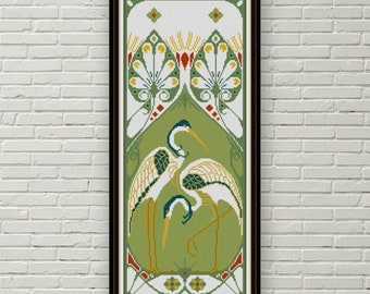 May include: A framed cross-stitch pattern featuring three white birds with green and yellow accents against a green background. The birds are stylized and have long necks and beaks. The background features a geometric design with a peacock feather motif.