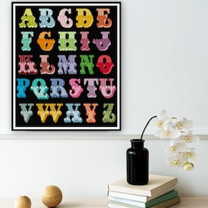 May include: A colourful alphabet poster with each letter in a different colour and a unique design. The letters are outlined in black and have a wavy, whimsical style. The background is black.