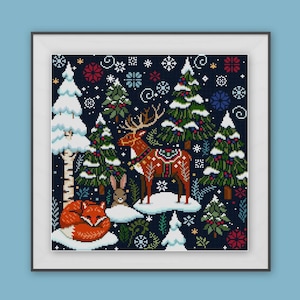 May include: Cross-stitch art of a winter forest scene with a deer, fox, and rabbit. The deer wears a decorative blanket. Snow-covered trees and snowflakes are scattered across the dark blue background. The artwork is framed in a white square frame.