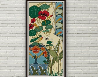 May include: A framed cross-stitch pattern featuring a floral design with red, orange, and white flowers, green leaves, and a bee. The background is a cream color with a blue and green border.
