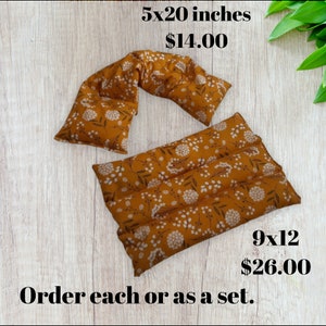 May include: Two brown fabric heat packs with a white floral pattern. The smaller pack is 5x20 inches and the larger pack is 9x12 inches.  Order each or as a set.