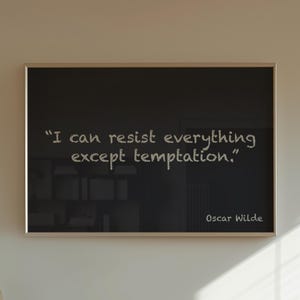 Puede incluir: Una obra de arte negra enmarcada con la cita "I can resist everything except temptation." de Oscar Wilde. La obra de arte cuelga sobre un mueble de madera con un jarrón y una pequeña escultura. Un libro titulado "CABINS" está en el mueble.