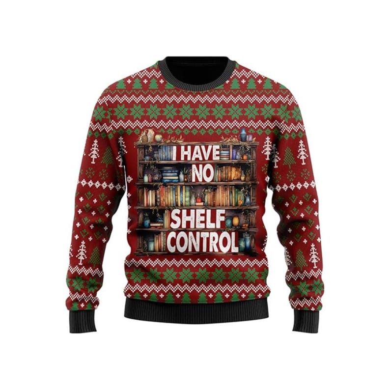 Red, Green, White, and Black ugly christmas sweater that has snowflake and tree patterns and says 'I have no shelf control' on a bookshelf full of books.