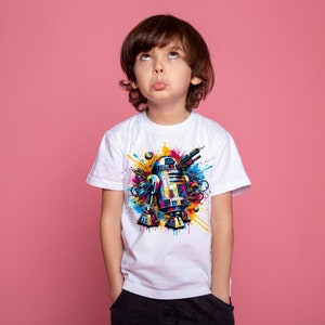 Puede incluir: Una camiseta blanca con un gr&aacute;fico colorido de un robot con un dise&ntilde;o de salpicaduras de pintura azul, amarilla y roja.