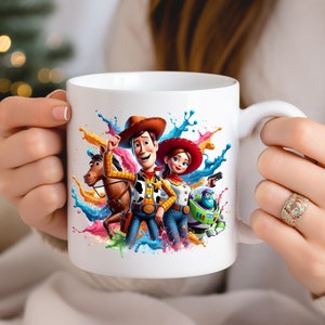 May include: White ceramic mug with a colorful paint splatter design featuring Woody, Jessie, and Buzz Lightyear from Toy Story.
