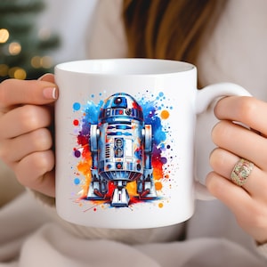 Puede incluir: Taza de cer&aacute;mica blanca con un dise&ntilde;o de acuarela colorido de R2-D2, un robot popular de la franquicia Star Wars.