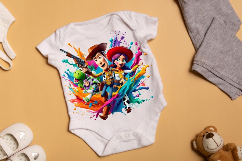 May include: White baby onesie with a colorful paint splatter design featuring Woody, Jessie, and Rex from Toy Story.