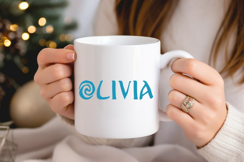 May include: A white ceramic mug with a blue swirl design and the name 'Olivia' printed on the front.