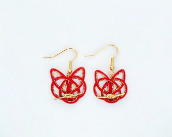 May include: A pair of red and gold earrings. Each earring features a cat-shaped design crafted from woven red material with gold accents. The earrings have gold-colored fish hook ear wires.