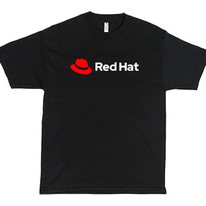 Puede incluir: Una camiseta negra de manga corta con el logotipo de Red Hat en el pecho. El logotipo consiste en un icono de un sombrero fedora rojo estilizado situado a la izquierda del texto blanco que dice Red Hat en una fuente sans-serif clara.