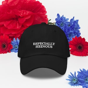 May include: A black baseball cap with white embroidered text that reads "ESPECIALLY HEINOUS".