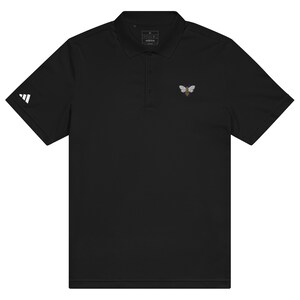 May include: A black polo shirt with a small embroidered bee design on the left chest. The shirt has a white Adidas logo on the left sleeve.