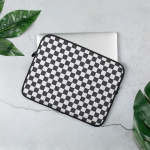 May include: A black and white checkered laptop sleeve with a zipper closure. The sleeve is made of a soft, durable material and is designed to protect your laptop from scratches and bumps.