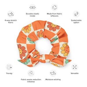 May include: A bright orange and cream scrunchie with a cheerful flower pattern. The scrunchie is made from fabric leftovers and has a durable elastic inside.