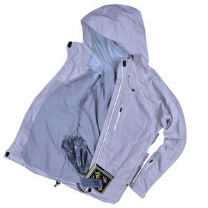 May include: A light gray hooded jacket with a zipper closure, featuring a light gray interior lining. The jacket has a small pocket on the chest and a tag that reads "GORE-TEX".