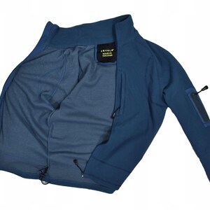 May include: A blue jacket with a high collar and a zipper closure. The jacket has a small pocket on the sleeve and a drawstring at the bottom. The interior is a lighter shade of blue. The jacket has the text "JEYVOL" on a tag.