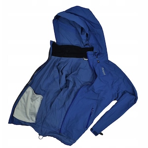 May include: A blue hooded jacket with a full zipper, open to reveal the interior. The jacket has a black collar and a mesh pocket on the inside. The sleeves are long, and the jacket appears to be made of a lightweight, water-resistant material.