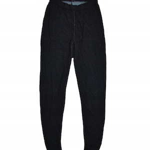 Puede incluir: Leggings negros con un diseño texturizado. Estos leggings tienen cintura alta y corte ajustado. La tela parece ser un material de punto.